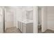 Bright bathroom featuring double sink vanity and doorway to lavatory and walk-in closet at 605 Lobelia Way, Locust Grove, GA 30248