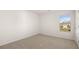 Clean bedroom with neutral carpet, white walls, and a window providing natural light at 605 Lobelia Way, Locust Grove, GA 30248