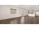 Open-concept living space with hardwood floors, a view of the kitchen, and natural lighting at 605 Lobelia Way, Locust Grove, GA 30248
