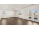 Bright living area featuring hardwood floors, large windows, and a view of the backyard at 605 Lobelia Way, Locust Grove, GA 30248