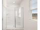 Glass enclosed shower featuring three shelves and a window for natural light at 605 Lobelia Way, Locust Grove, GA 30248