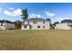 Spacious backyard featuring a large lawn and view of the home's rear exterior at 191 Kyndal Dr, Hampton, GA 30228