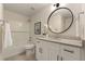 Beautiful bathroom featuring a round mirror, granite countertop, white vanity, and shower over tub with white tile at 191 Kyndal Dr, Hampton, GA 30228