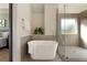 Bright bathroom features a modern tub next to a shower with gray tiling at 191 Kyndal Dr, Hampton, GA 30228