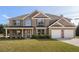 Charming two-story brick home featuring a well-manicured lawn, two-car garage and beautiful landscaping at 191 Kyndal Dr, Hampton, GA 30228