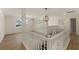 Bright, open hallway with wood floors, white railing, and modern light fixtures at 191 Kyndal Dr, Hampton, GA 30228