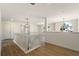 Open hallway with wooden floors, white railing and stylish light fixtures at 191 Kyndal Dr, Hampton, GA 30228