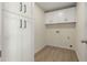 Well-lit laundry room with laminate floors, ample cabinet space, and utility connections at 191 Kyndal Dr, Hampton, GA 30228