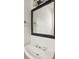 Elegant bathroom featuring a stylish sink with a dark framed mirror and a towel rack at 2890 Winterhaven Ct, Atlanta, GA 30360