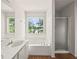 Bright bathroom featuring a soaking tub, a glass shower, and a view of the trees at 2890 Winterhaven Ct, Atlanta, GA 30360
