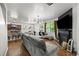 Open living room and kitchen area with modern lighting, fireplace, and stainless steel appliances at 468 Lake Ridge Ln, Fairburn, GA 30213