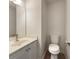 Bathroom featuring a toilet, mirror, and sink with white countertops and wood-look flooring at 6001 Deer Springs Nw Ln, Acworth, GA 30101