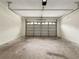 A clean and empty garage with a functional overhead door ready for parking or storage at 6001 Deer Springs Nw Ln, Acworth, GA 30101