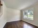 Bright living room featuring hardwood floors, a large window, and crown molding at 6001 Deer Springs Nw Ln, Acworth, GA 30101