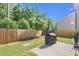 Private backyard with a wooden fence, lush greenery, and a patio area at 104 Auburn Crossing Way, Auburn, GA 30011