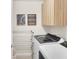 Modern laundry room featuring a washer, dryer, storage cabinets, and wall decorations creating a functional and stylish space at 104 Auburn Crossing Way, Auburn, GA 30011