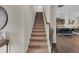 Carpeted staircase leading to the upper level with a view of the kitchen at 104 Auburn Crossing Way, Auburn, GA 30011
