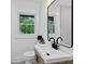 Bright bathroom with a single sink vanity, a large framed mirror and a window with a view of lush greenery at 1643 Flintwood Se Dr, Atlanta, GA 30316