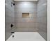 Modern bathroom featuring gray tiling, tub, and built-in shower niche at 1643 Flintwood Se Dr, Atlanta, GA 30316