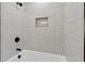 Bathroom tub and shower with sleek vertical tiles and black hardware at 1643 Flintwood Se Dr, Atlanta, GA 30316