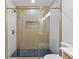 Modern shower featuring glass door, neutral tiling, and built-in shower niche at 1643 Flintwood Se Dr, Atlanta, GA 30316