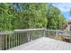 Wooden back deck overlooks lush greenery, perfect for outdoor relaxation and entertainment at 200 Ridge Bluff Ln, Suwanee, GA 30024