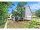 Spacious backyard with a privacy fence features a gray home exterior, lawn, and mature trees at 200 Ridge Bluff Ln, Suwanee, GA 30024