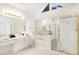 Bright bathroom with double sinks, walk-in shower, gold accents, and a triangular window at 200 Ridge Bluff Ln, Suwanee, GA 30024