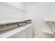 Efficient laundry room with washer, dryer, wire shelving and storage space at 200 Ridge Bluff Ln, Suwanee, GA 30024