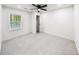 Bright bedroom with a ceiling fan, window view, neutral carpet, and an open closet at 2798 Hutchins Rd, Lawrenceville, GA 30044