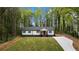 Charming single-story home featuring a red door, black shutters and a spacious, well-manicured front yard at 2798 Hutchins Rd, Lawrenceville, GA 30044