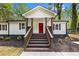 Home entrance with a vibrant red door and a landscaped walkway at 2798 Hutchins Rd, Lawrenceville, GA 30044