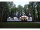 Charming home exterior featuring a bright red front door, manicured lawn, and mature trees in the background at 2798 Hutchins Rd, Lawrenceville, GA 30044