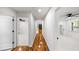 Long hallway with wood floors and white walls leading to bedrooms with ceiling fans at the end at 2798 Hutchins Rd, Lawrenceville, GA 30044