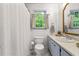 Bathroom features a toilet, white shower curtain and a window with natural light at 4150 Kalb Sw Ct, Smyrna, GA 30082