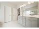 Bright bathroom featuring double sinks with white cabinets and a separate shower at 5322 Burrus Sw Ln, Mableton, GA 30126