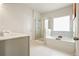 Bright bathroom featuring a soaking tub and glass enclosed shower at 5322 Burrus Sw Ln, Mableton, GA 30126