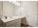 This bathroom features wood-look flooring, a vanity with a large mirror, and a modern white door at 5322 Burrus Sw Ln, Mableton, GA 30126