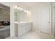 Bathroom featuring double sinks with gray cabinets and a doorway to the bedroom at 5322 Burrus Sw Ln, Mableton, GA 30126