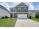Attractive two-story home featuring a well-kept lawn, brick accents, a two-car garage, and a cozy front porch at 5322 Burrus Sw Ln, Mableton, GA 30126