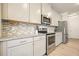 Bright kitchen featuring stainless appliances, granite countertops, and gray cabinets at 5322 Burrus Sw Ln, Mableton, GA 30126
