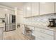 Bright kitchen boasts stainless refrigerator, white cabinets, granite counters, and desk area at 5322 Burrus Sw Ln, Mableton, GA 30126