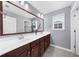 Bathroom with a double vanity, large mirror, dark wood cabinets, and white countertops providing ample space at 2321 Norbury Se Cv, Smyrna, GA 30080