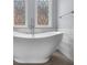 Freestanding tub under beautiful stained-glass windows at 2321 Norbury Se Cv, Smyrna, GA 30080