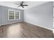 Bright bedroom features a ceiling fan, light gray walls, and hardwood floors at 2321 Norbury Se Cv, Smyrna, GA 30080