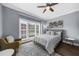 Bedroom with hardwood floors, a ceiling fan, and a cozy chair by the window with natural light at 2321 Norbury Se Cv, Smyrna, GA 30080