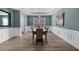 Classic dining room with white wainscoting, hardwood floors, and modern light fixture at 2321 Norbury Se Cv, Smyrna, GA 30080