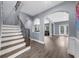 Spacious foyer featuring hardwood floors, a staircase with wrought iron railing and arched doorway to the living room at 2321 Norbury Se Cv, Smyrna, GA 30080