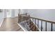 Hallway and staircase featuring hardwood floors, gray walls, and wrought iron spindles at 2321 Norbury Se Cv, Smyrna, GA 30080