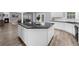 Open kitchen with large island, black countertops, white cabinets, and hardwood flooring at 2321 Norbury Se Cv, Smyrna, GA 30080